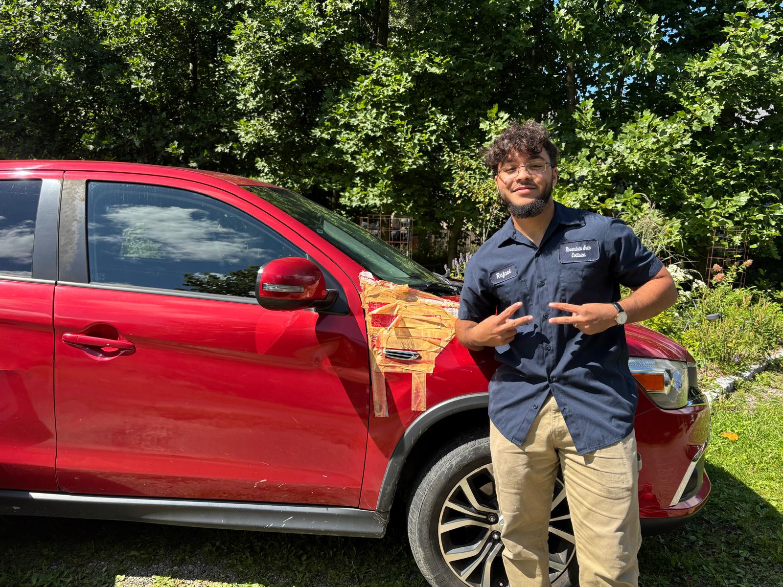 Raphael Estrella beside the red Mitsubishi Outlander at the on-site parts replacement job